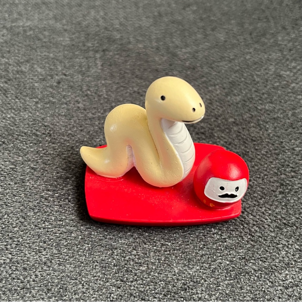 Cute Snake and Daruma Figurine on Red Base